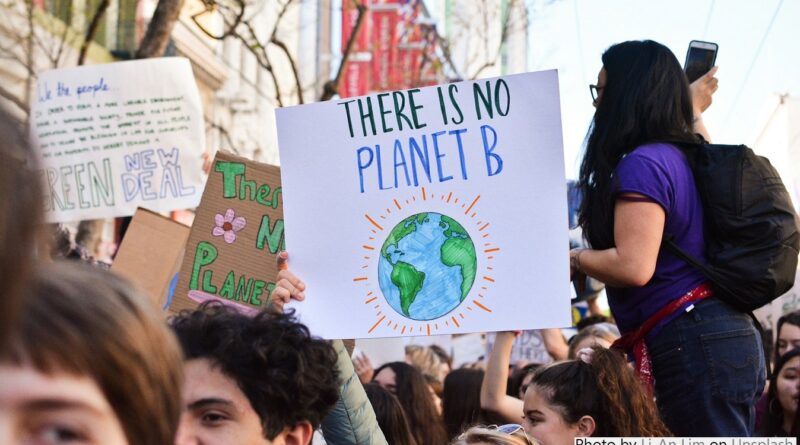 Climate protest with a group of young people with a sign reading There is no planet B